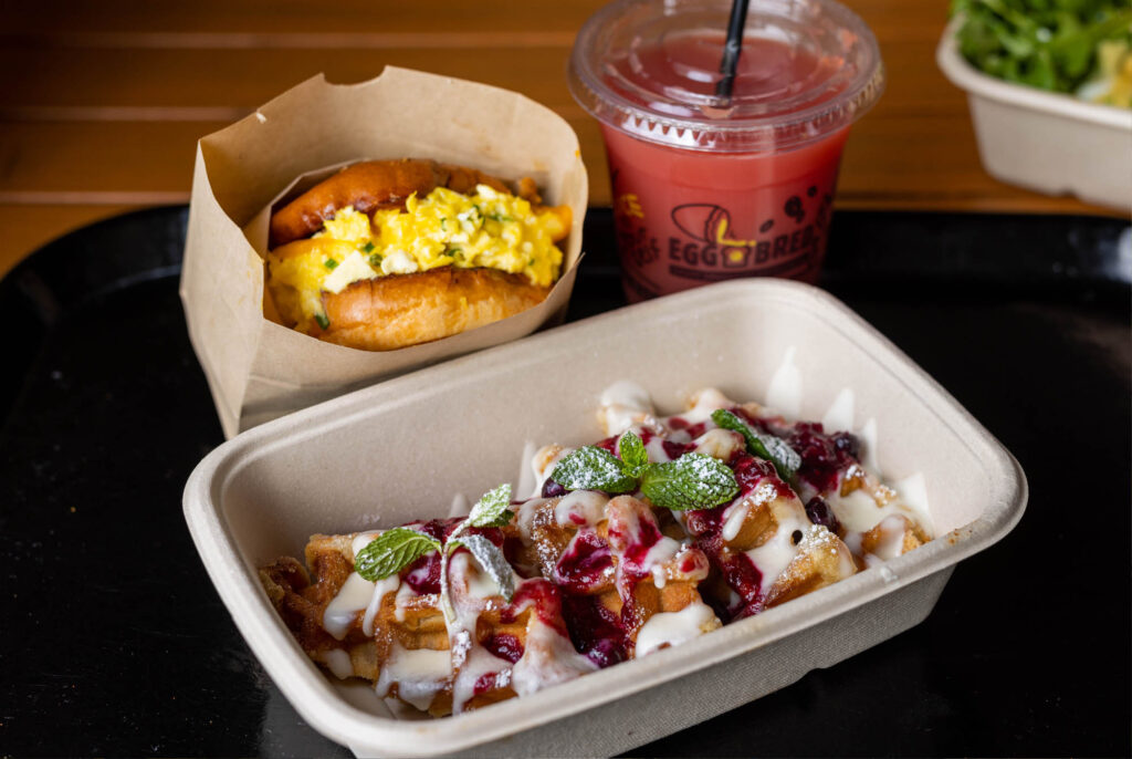 waffles and an egg breakfast sandwhich with a smoothie